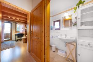 Un baño con lavabo, inodoro y espejo. en Haus Alpenruhe, en Königsleiten 30 fotos más