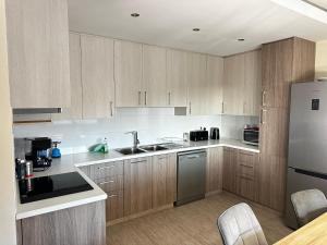 una cucina con armadietti in legno ed elettrodomestici in acciaio inossidabile di ANTHEMIs COTTAGE RED a Kyperounda