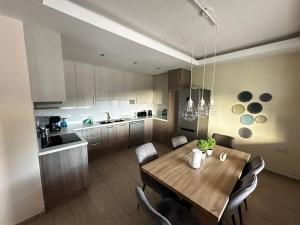 una cucina con un tavolo di legno e una sala da pranzo di ANTHEMIs COTTAGE RED a Kyperounda