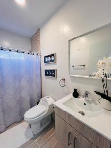 a bathroom with a white toilet and a sink at Boho Vibes Punta Cana in Punta Cana