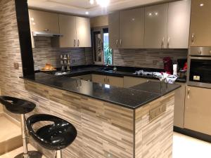 阿加迪尔Appartement Premium à Agadir Calme, Clim,Plage à 5 min的厨房配有黑色柜台和黑色凳子