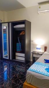 ein Schlafzimmer mit einem Bett und einem Schrank mit Schreibtisch in der Unterkunft Kata Lina guesthouse in Kata Beach