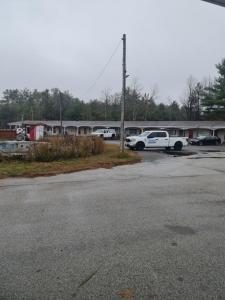 ein Parkplatz mit vor einem Gebäude geparkten Autos in der Unterkunft Skyways Motel in Gravenhurst