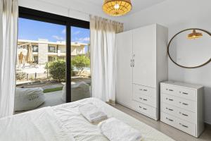 a white bedroom with a bed and a large window at The G Cribs Sunlit - El Gouna in El Gouna +28 photos