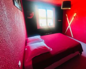 a red bedroom with a bed and a window at L'Acro Love in Nissan-lez-Enserune