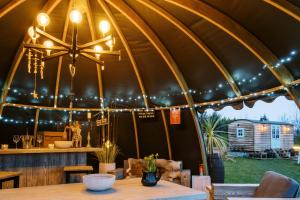 Un comedor con una gran carpa con una mesa. en Herbie's Shepherd's Hut - Wellness & Hot Tub, en Bottesford