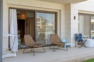 three chairs sitting on a porch next to a window at The G Cribs Sunlit - El Gouna in El Gouna