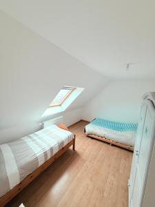 a attic bedroom with two beds and a window at MAISON SERENITY Bohars in Bohars