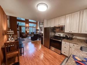 una cucina e un soggiorno con armadi bianchi e tavolo di Apres Moose a Brenchley Mobile Home Park