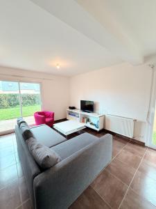 a living room with a couch and a tv at MAISON SERENITY Bohars in Bohars