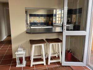 a small kitchen with two stools and a sink at Outspan Lodge in Fish hoek +8 photos