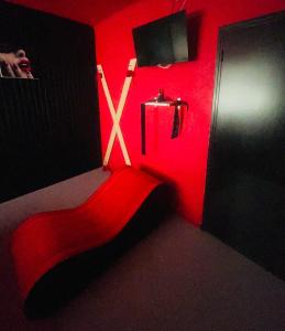 ein roter Raum mit einer Bank vor einer Tür in der Unterkunft L'Acro Love in Nissan-lez-Enserune