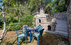 a blue table and chairs in a yard at Studio Veli A in Veli Lošinj