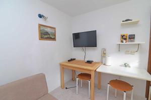 a room with a desk and a tv on a wall at Studio Veli A in Veli Lošinj