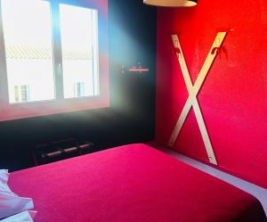 Ein Schlafzimmer mit einem rosa Bett und einer Axt an der Wand in der Unterkunft L'Acro Love in Nissan-lez-Enserune