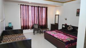 a bedroom with a bed and a window with curtains at Hiral residency in Matheran +6 photos
