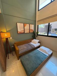 two beds in a room with two windows at Iguazu Lofts in Puerto Iguazú +75 photos
