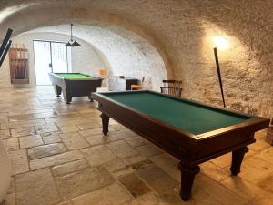 a room with a pool table in a stone building at Château Gautoul in Puy-lʼÉvêque