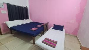 a room with two beds and a table and a couch at SPIDEY's PITSTOP in Auroville +7 photos