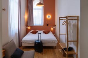 a hotel room with a bed with a suitcase at Hotellerie de l'Abbaye du Désert in Bellegarde