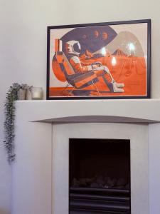 a fireplace with a picture on top of it at Stylish, Spacious City Hideaway - Sleeps up to 9 in Cardiff