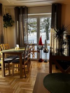 Willa Krynica في كرينيتسا زدروي: غرفة طعام مع طاولة عليها قبعة سانتا على النافذة