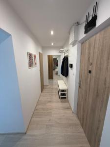 a hallway with white walls and a wooden door at Thurzova Residence 5 in Martin