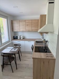 a kitchen with wooden cabinets and a table and a sink at Thurzova Residence 5 in Martin