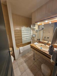 a bathroom with a sink and a large mirror at Hôtel 1er Consul Rouen in Rouen +79 photos