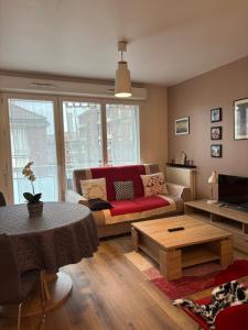 a living room with a red couch and a table at Jasmin in Rouen