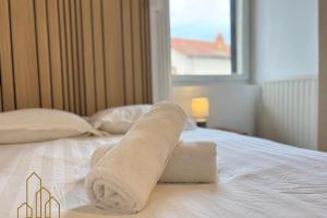 un paio di asciugamani arrotolati su un letto di Le Dourdein - Chic & Confort a Roanne