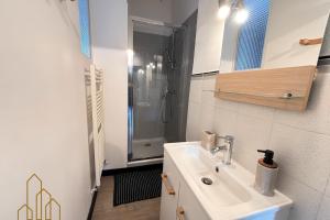 un bagno con lavandino e doccia di Le Dourdein - Chic & Confort a Roanne