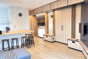 una cucina con mobili in legno e sgabelli da bar di Le Dourdein - Chic & Confort a Roanne Altre 5 foto