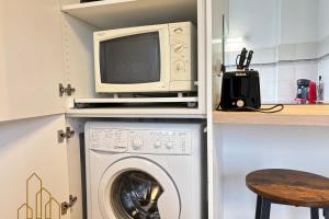 una cucina con forno a microonde e lavatrice. di Le Dourdein - Chic & Confort a Roanne