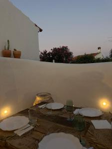 un tavolo con piatti e bicchieri da vino sopra di Casa do Juiz a Barca da Amieira