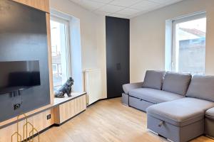 un soggiorno con divano e TV a schermo piatto di Le Dourdein - Chic & Confort a Roanne