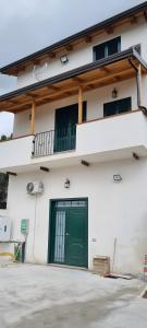a building with a green door and a balcony at La Casa di Paddington in Piana di Caiazzo