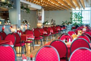 eine Reihe roter Stühle und Tische in einem Restaurant in der Unterkunft Hotel Slovakia in Žilina