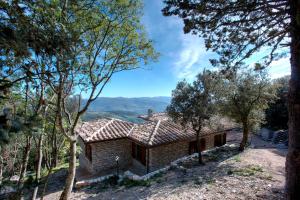 una casa en una colina con árboles en primer plano en Casa Vacanze Assisi, en Spello