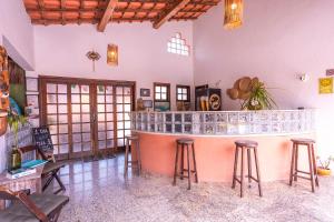 a bar in the middle of a room with stools at Pousada In Bali - Maresias in Maresias