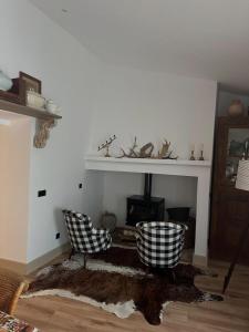 un soggiorno con due sedie e un camino di Casa do Juiz a Barca da Amieira Altre 16 foto