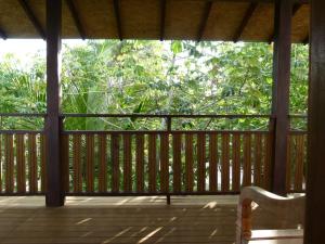 a porch with a chair on a wooden deck at Jasmim Manga in Marau +4 photos