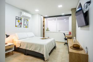 a bedroom with a bed and a tv and a window at 102 Norte cali - The view in Cali