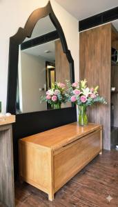 Beautiful Pool View Studio in Kata في شاطئ كاتا: حمام مع مغسلة مع زهور في المرآة