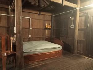 Un dormitorio con una cama en una habitación de madera. en Sconvolt Homestay, en Kratié