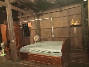 Un dormitorio con una cama en una habitación de madera. en Sconvolt Homestay, en Kratié