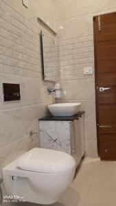 Un baño con un inodoro blanco y un lavabo. en PD Residency, en Duttnager
