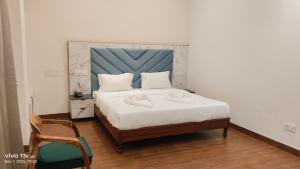 a bedroom with a bed with a blue headboard and a chair at PD Residency in Duttnager
