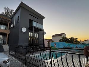 Starlight Inn Boutique Hotel في Humewood: منزل أسود أمامه مسبح