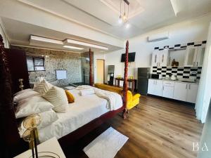 Starlight Inn Boutique Hotel في Humewood: غرفة نوم مع سرير كبير ومطبخ